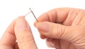 Woman threading sewing needle on white background, closeup