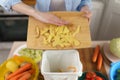 Woman throwing away potato peels for recycling. Female composting organic waste at home. Person put food leftovers into bokashi