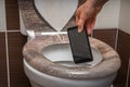 Woman throwing mobile phone in the toilet bowl Royalty Free Stock Photo