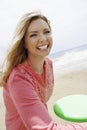 Woman Throwing Frisbee On Beach