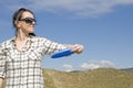 Woman throwing frisbee in sand dunes Royalty Free Stock Photo