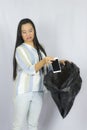 Woman throwing her phone into the garbage bag, posing isolated on gray background