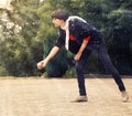 Woman throwing a petanque ball in th park on holidays