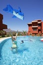 Woman throwing toy inflatable dolphin in air