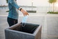 Woman throwing a used surgical face mask in the trash outdoors Royalty Free Stock Photo