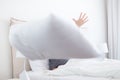 Woman throwing white pillow at camera. Royalty Free Stock Photo