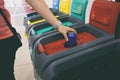 woman throws the aluminum can into one from four bins for sorting garbage