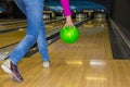 A woman throws a bowling ball, rear view. People, leisure, sports and entertainment concept- a happy young woman throws a ball in Royalty Free Stock Photo