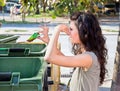 Woman throws garbage in dumpster Royalty Free Stock Photo