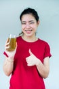 A woman thumb up and holding a glass of green tea