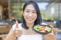 Woman thumbs up and holding salad with sauteed vegetables for eating Breakfast Royalty Free Stock Photo