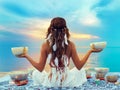 Woman with Tibetan Singing Bowls. Relaxation and Meditation at Sunset Beach. Sound Healing Therapy. Peaceful Women Silhouette Royalty Free Stock Photo