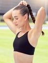 Woman tie her hair before start of workout and running on a track. Young girl with plait or braid hairstyle, tying it