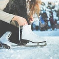 Woman tie shoelaces figure skates at ice rink close-up