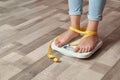 Woman with tied legs measuring her weight using scales Royalty Free Stock Photo