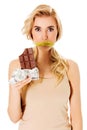 Woman with tied mouth holding bar of chocolate