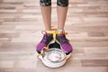 Woman tied with tape measuring her weight using scale Royalty Free Stock Photo