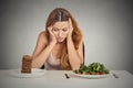 Woman tired of diet restrictions deciding to eat healthy food or sweet cookies Royalty Free Stock Photo