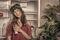 Woman with tired look standing next to open fridge. Girl holding glass of milk. Lady with curly hair and green headband Royalty Free Stock Photo