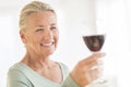 Woman Toasting Red Wineglass At Home