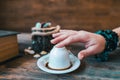 Woman toch the mug before telling fortune with turkish coffee cup.