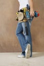 Woman With Toolbelt And Drill Leaning Against Wall Royalty Free Stock Photo