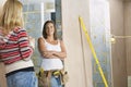 Woman With Toolbelt Talking To Friend