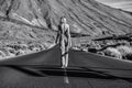 Woman topless traveler in jeans walking away on the street over the wild mountains landscape. Back view. Feminist Royalty Free Stock Photo