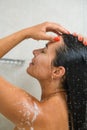 Woman touch forehead, wash hair in shower Royalty Free Stock Photo