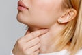 Woman touches fingers of sore throat. Thyroid gland, painful swallowing, tonsillitis