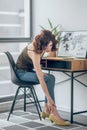 Woman touching her aching feet in a new shoe