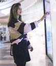 Woman touching interactive information kiosk at mall - using navigation system