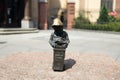 Woman touching a small dwarf statue on the market square in Wroclaw. Famous small statues