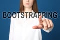 Woman touching virtual screen with word BOOTSTRAPPING against background, focus on hand Royalty Free Stock Photo
