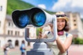 Tourist admiring the views of the resort architecture of the city through a street telescope