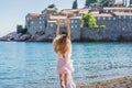 Woman tourist on background of beautiful view of the island of St. Stephen, Sveti Stefan on the Budva Riviera, Budva Royalty Free Stock Photo