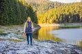 Woman tourist in background of Panoramic morning view of Black Lake Crno Jezero. Calm summer scene of Durmitor Royalty Free Stock Photo