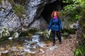 Woman tourist with backpack in a cave with a river