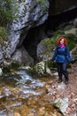 Woman tourist with backpack in a cave with a river