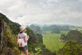 Woman tourist with backpack enjoying valley view from top of a mountain Royalty Free Stock Photo