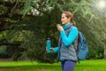 woman tourist with a backpack holds a thermos in her hands. forest, nature, hiking, active lifestyle, camping