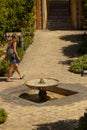 A woman tourist with a backpack is walking in the courtyard of the Alcazar