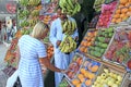 Woman tourist buying fruits at street seller. mangoes, pomegranates, guava