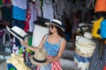 Woman Tourist Choosing Hat On Asian Street Market Of Clothes Young Female Shopping On Vacation Royalty Free Stock Photo