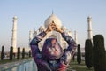 Woman tourist doing yoga mudra infront of Taj Mahal