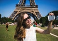Woman tourist at Eiffel Tower smiling and making Royalty Free Stock Photo