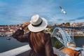 Woman tourist enjoying beautiful view of Porto city old town with river and famous iron bridge. Summer holiday vacation Royalty Free Stock Photo