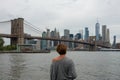 Woman tourist enjoying view of Brooklyn Bridge and Manhattan skyscrapers Royalty Free Stock Photo