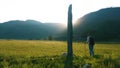 Woman tourist examines ancient stone stelts of the Turkic period in the Altai mountains