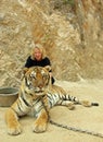 Woman tourist frowning in concern for cruel conditions of chained tiger Bangkok Tiger Temple in Thailand Royalty Free Stock Photo